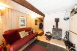 Ski lodge-themed entrance room with a wood stove and bonus futon